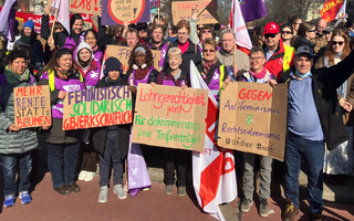 Ein Gruppenbild von Frauen beim 8. März mit Schildern. 